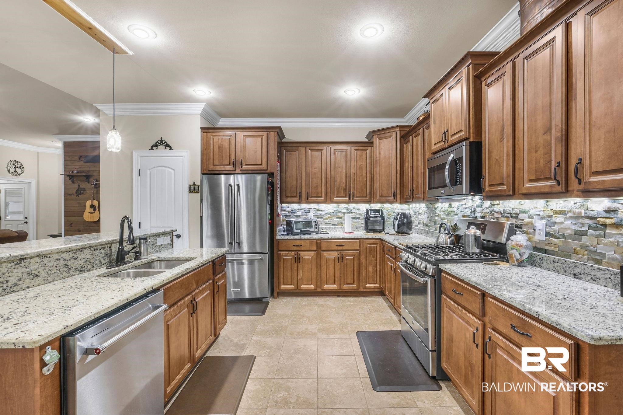 1086 Destin Avenue Foley, AL 36535 - Photo 4 of 30 Kitchen featuring light stone countertops, sink, stainless steel appliances, decorative light fixtures, and crown molding