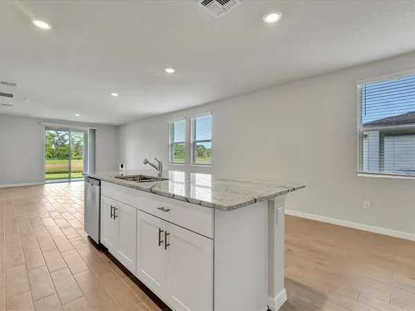 a kitchen with granite countertop a sink and cabinets