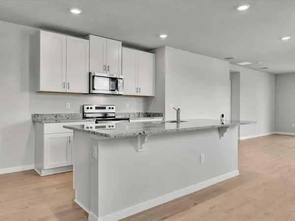 a kitchen with stainless steel appliances granite countertop a sink a stove and a refrigerator