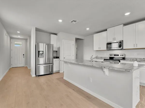 a kitchen with stainless steel appliances a refrigerator sink stove and cabinets