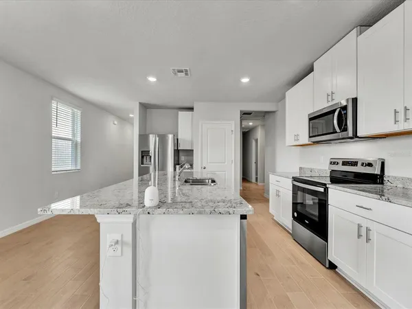 a kitchen with stainless steel appliances granite countertop a sink refrigerator and microwave