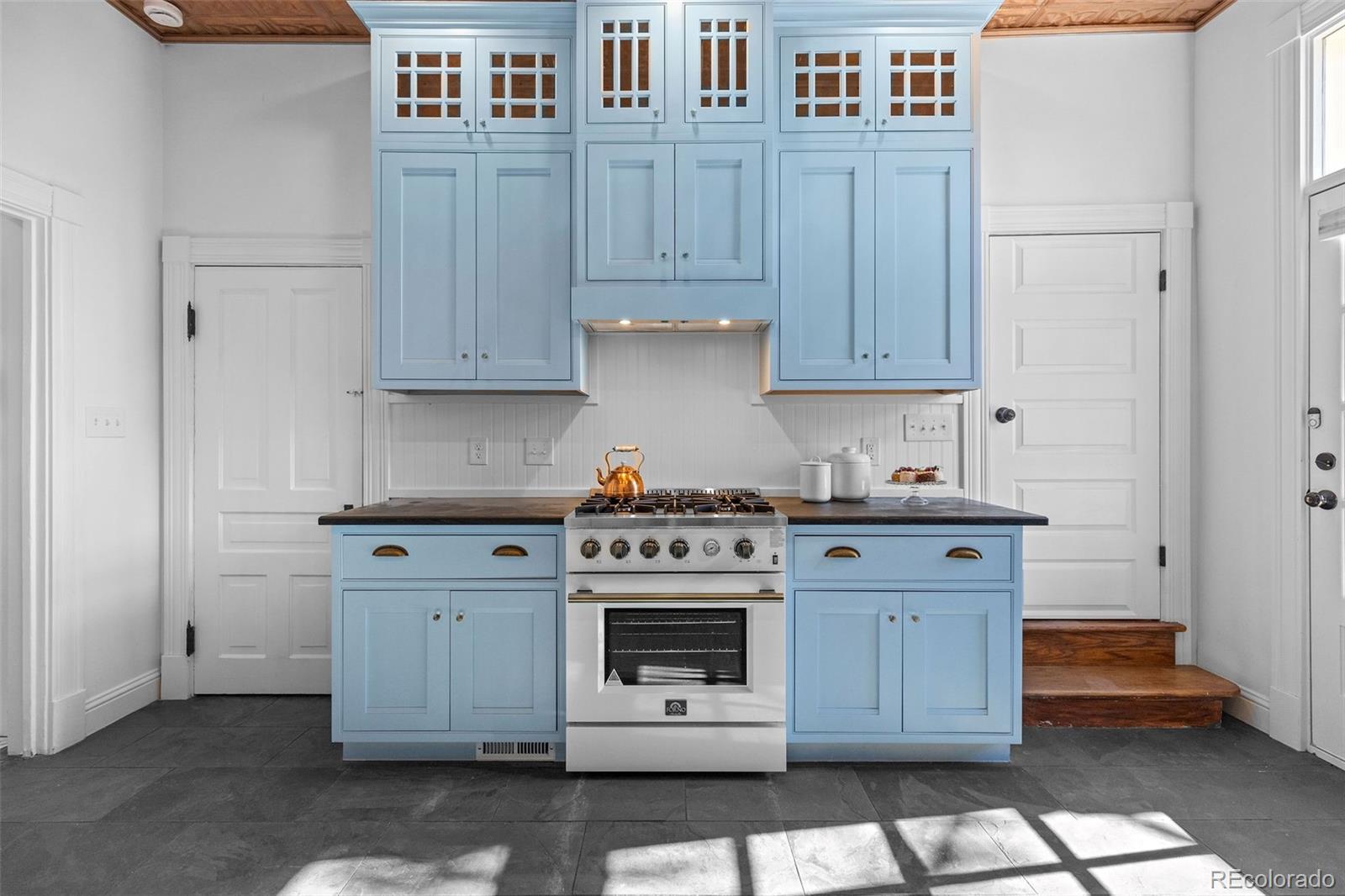 1389 Stuart Street Denver, CO 80204 - Photo 13 of 50 a kitchen with stainless steel appliances granite countertop a stove and a white cabinets
