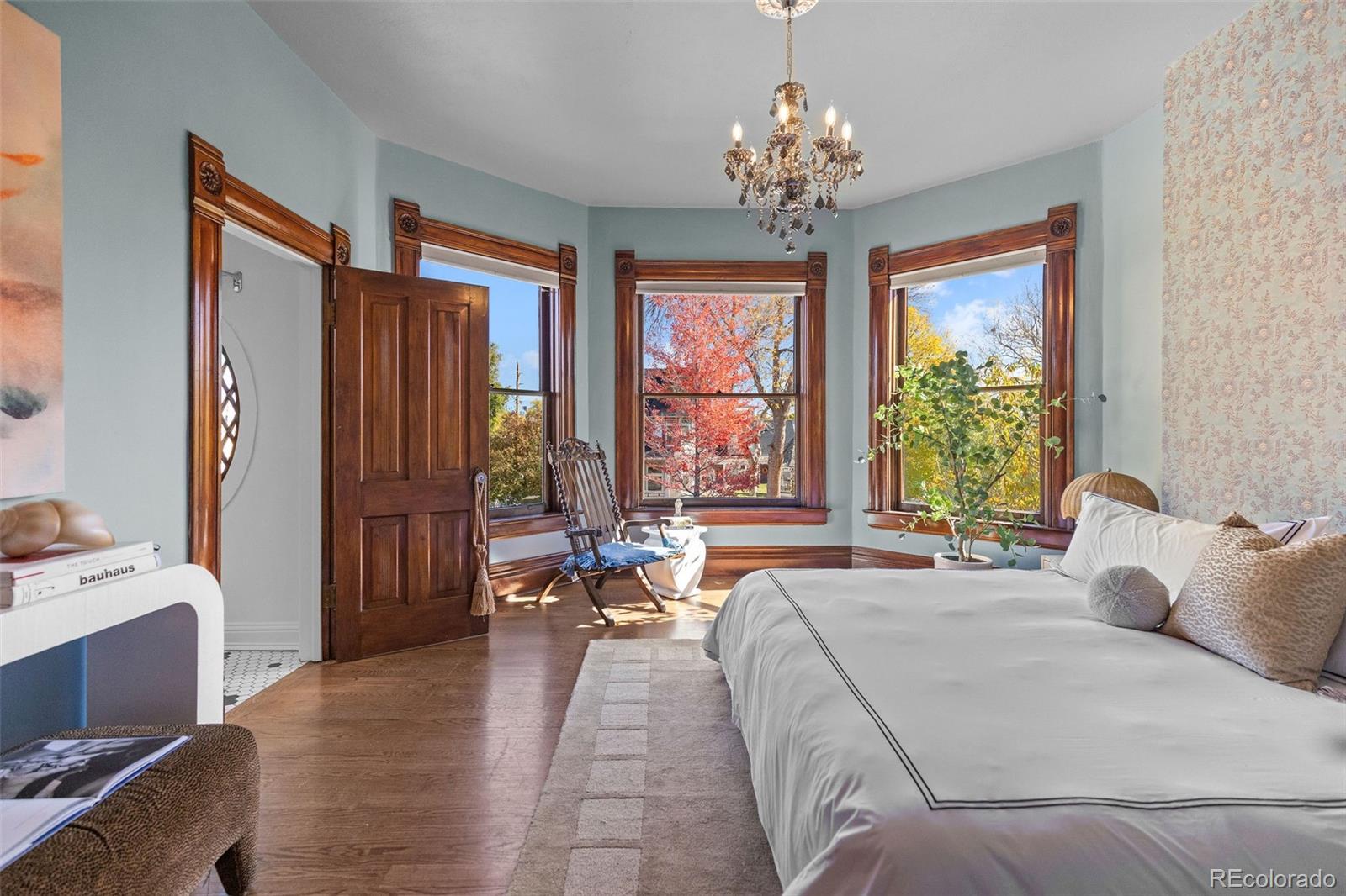 1389 Stuart Street Denver, CO 80204 - Photo 21 of 50 a spacious bedroom with a large bed and a chandelier