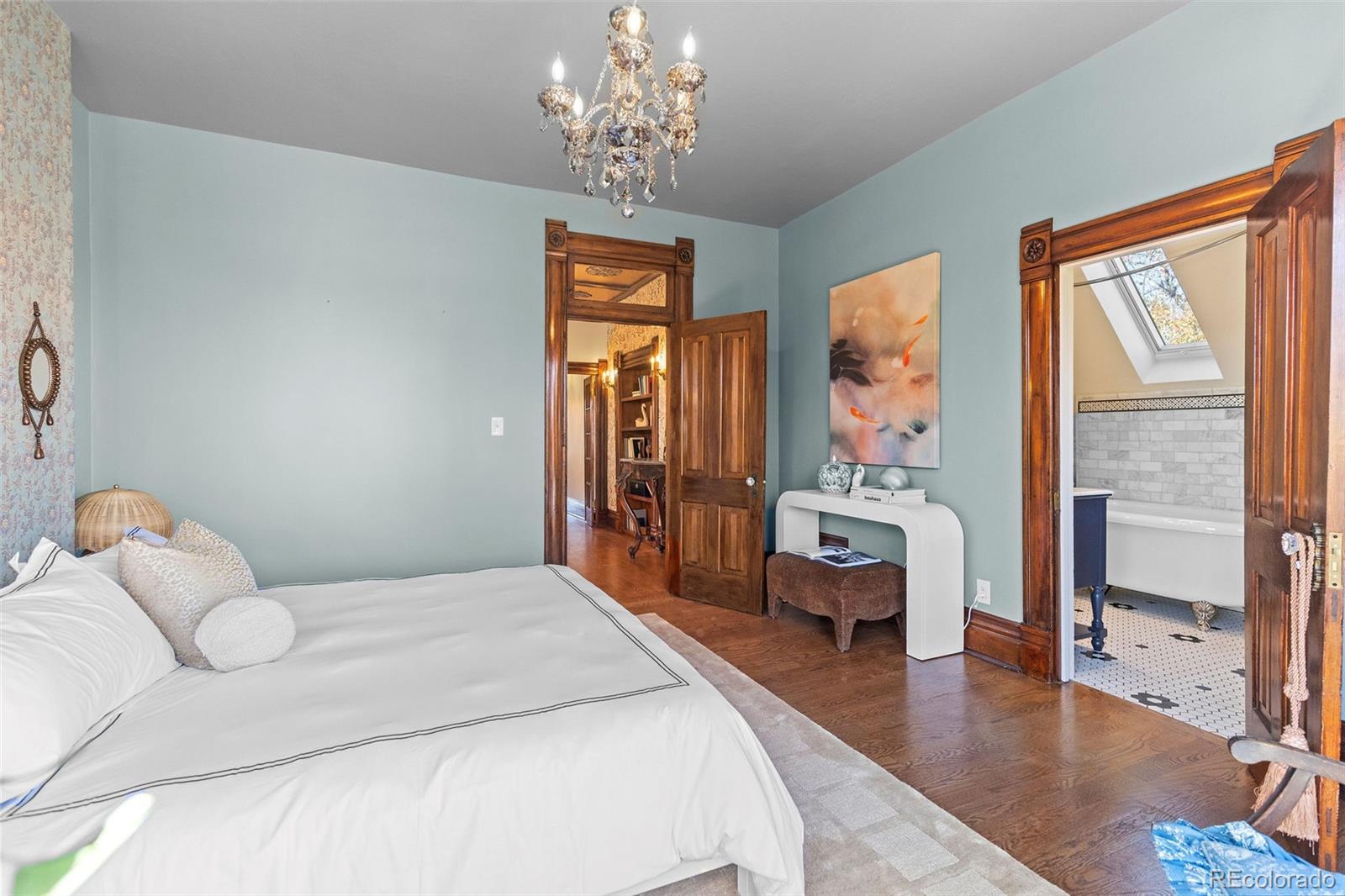 1389 Stuart Street Denver, CO 80204 - Photo 23 of 50 a bedroom with a large bed and a chandelier