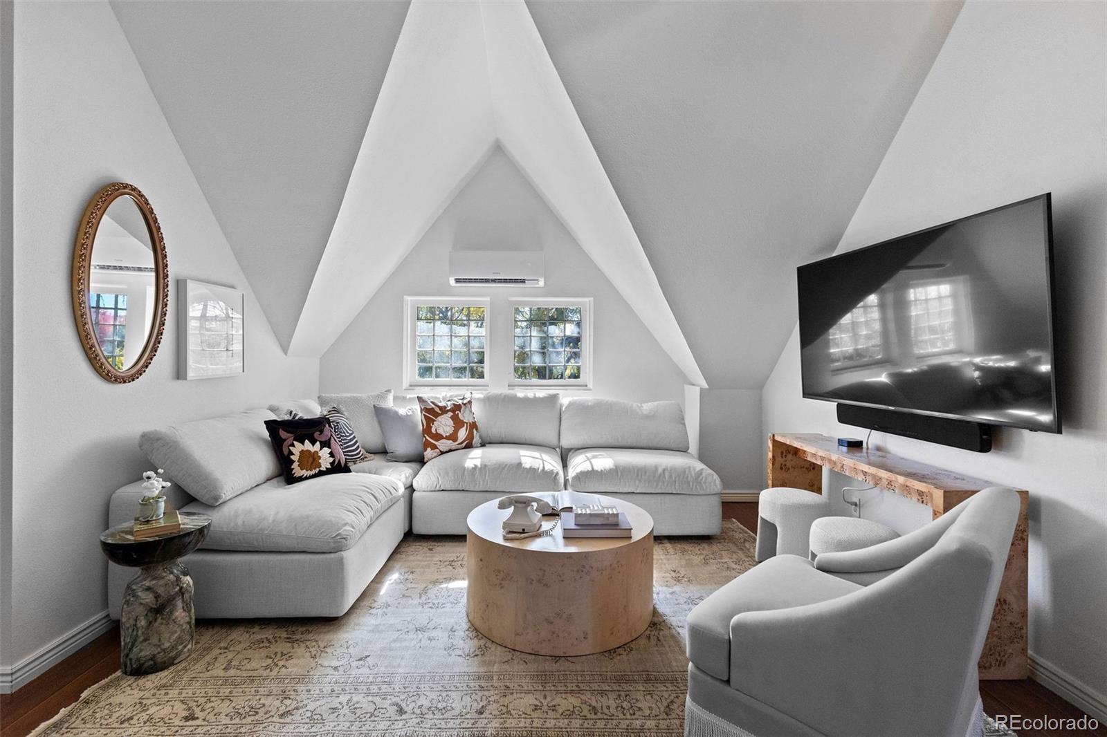 1389 Stuart Street Denver, CO 80204 - Photo 38 of 50 a living room with furniture a flat screen tv and a large window