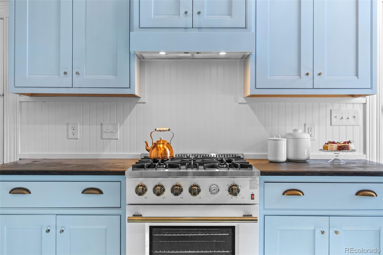 1389 Stuart Street Denver, CO 80204 - Photo 10 of 50 a white stove top oven sitting inside of a kitchen and white cabinets