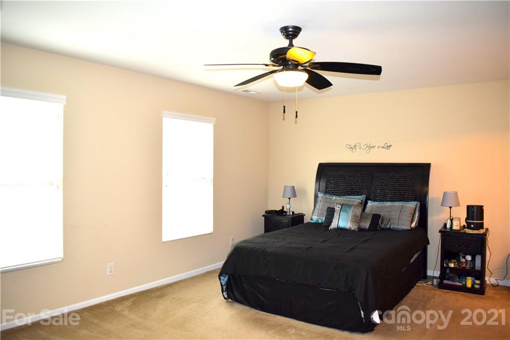 12021 Bending Branch Road Charlotte, NC 28227 - Photo 11 of 16 a bedroom with a bed and a chandelier
