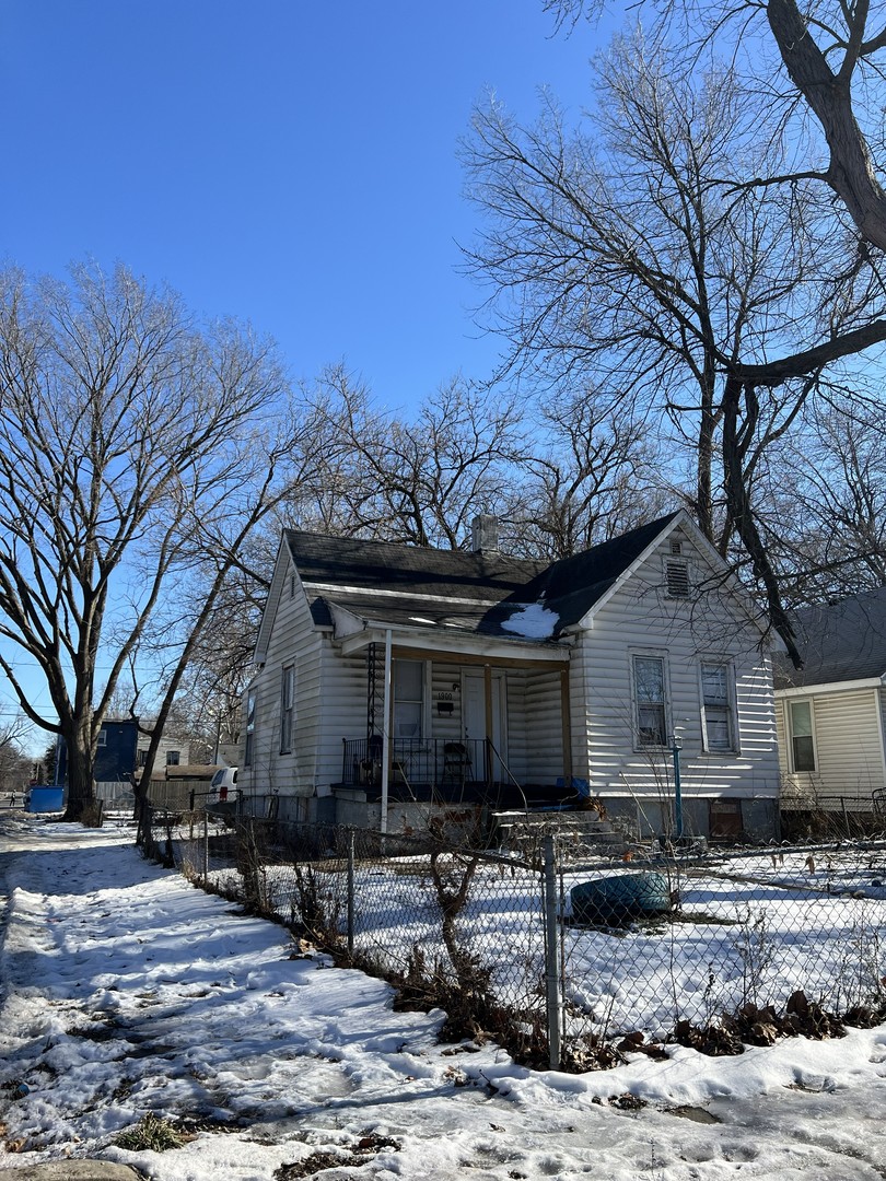 a view of a house with a yard and wooden fence