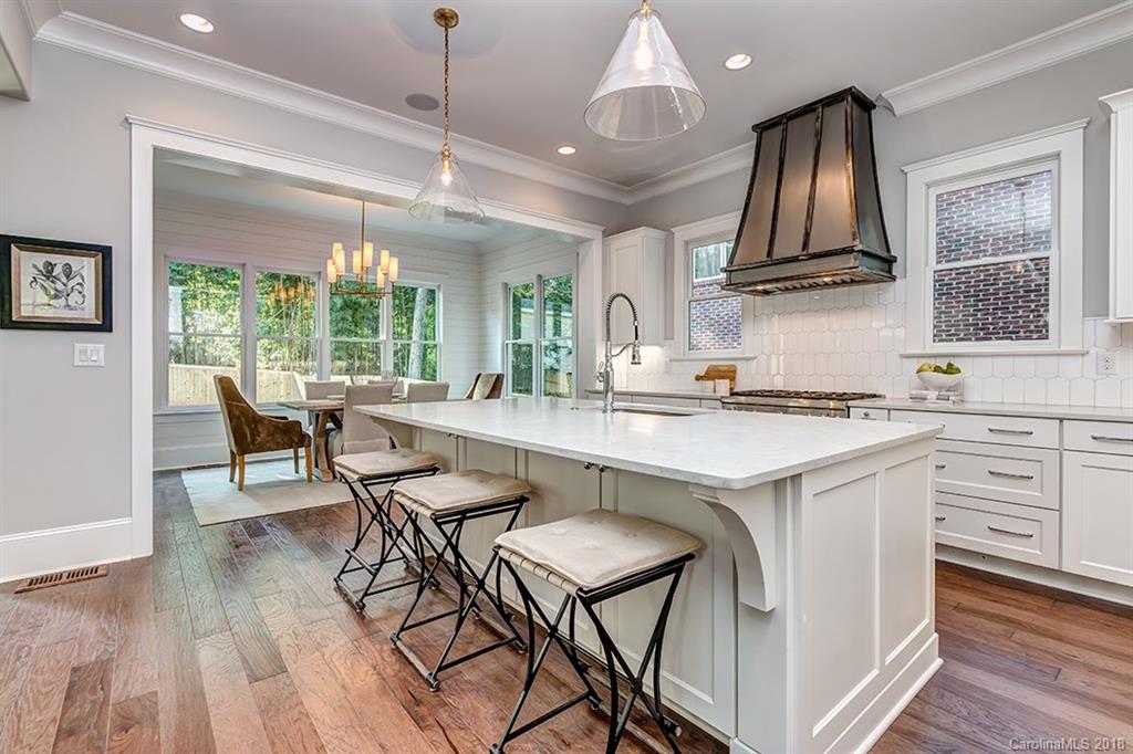 736 Ellsworth Road, Unit 44 Charlotte, NC 28211 - Photo 12 of 36 a kitchen with a table chairs stove and wooden floor