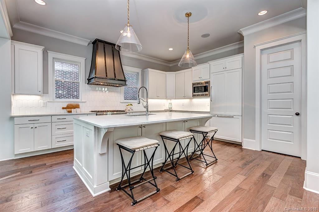 736 Ellsworth Road, Unit 44 Charlotte, NC 28211 - Photo 15 of 36 a kitchen with kitchen island granite countertop a sink cabinets and wooden floor