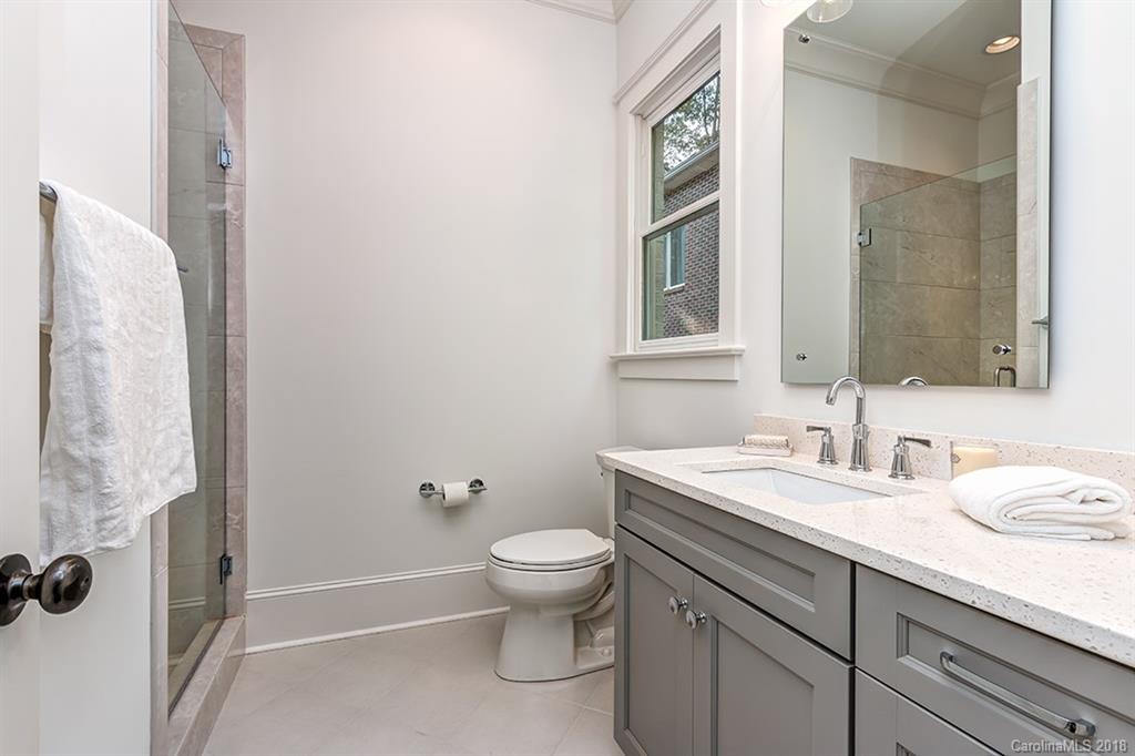 736 Ellsworth Road, Unit 44 Charlotte, NC 28211 - Photo 6 of 36 a bathroom with a granite countertop sink a toilet and a mirror