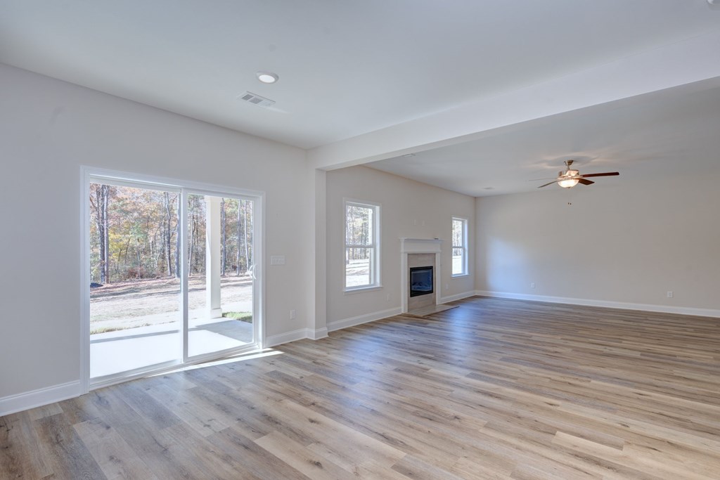 8701 McKee Road Upatoi, GA 31829 - Photo 11 of 35 an empty room with wooden floor and windows