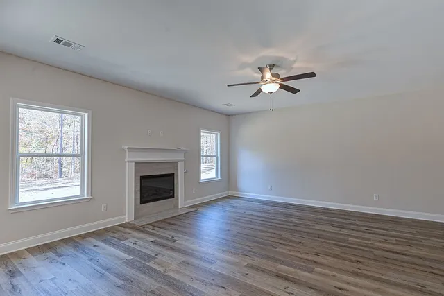 a view of an empty room with a kitchen and a window