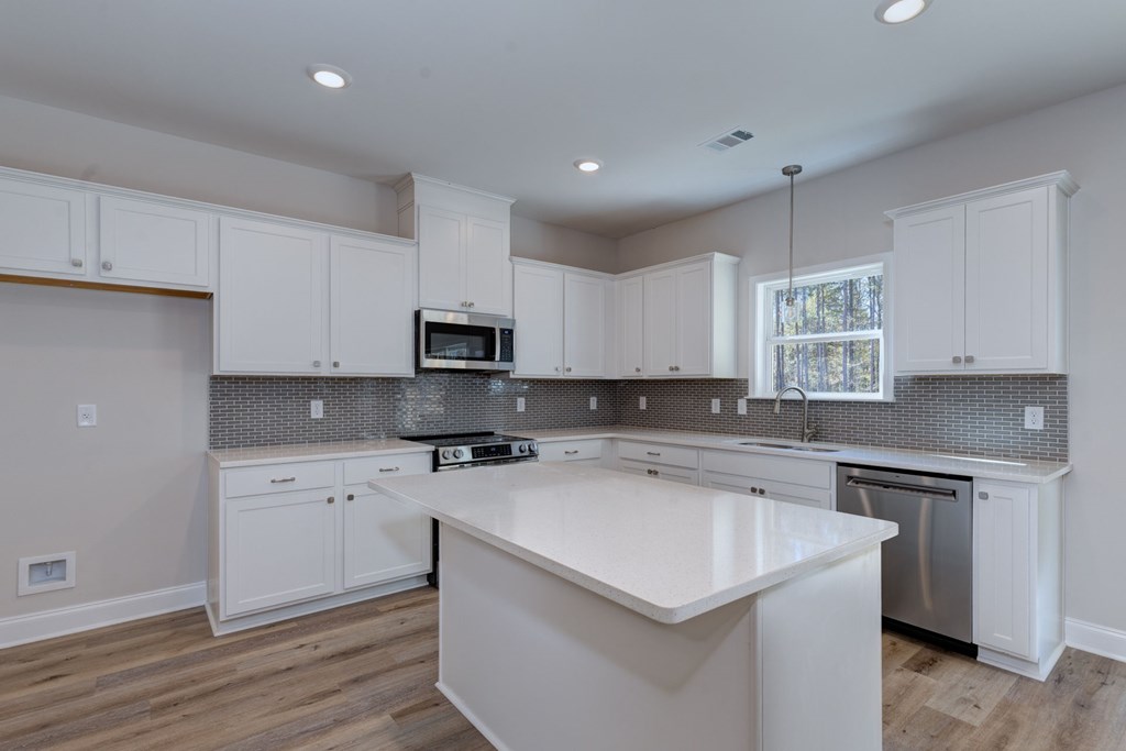 8701 McKee Road Upatoi, GA 31829 - Photo 10 of 35 a kitchen with a sink a stove a refrigerator and white cabinets