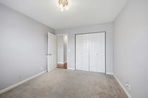a view of an empty room and chandelier fan