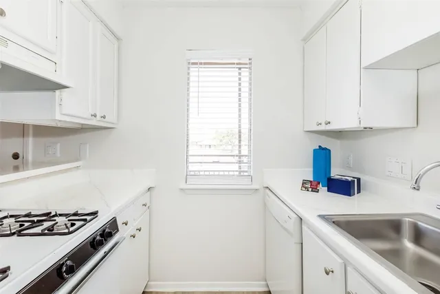 a kitchen with white cabinets and appliances