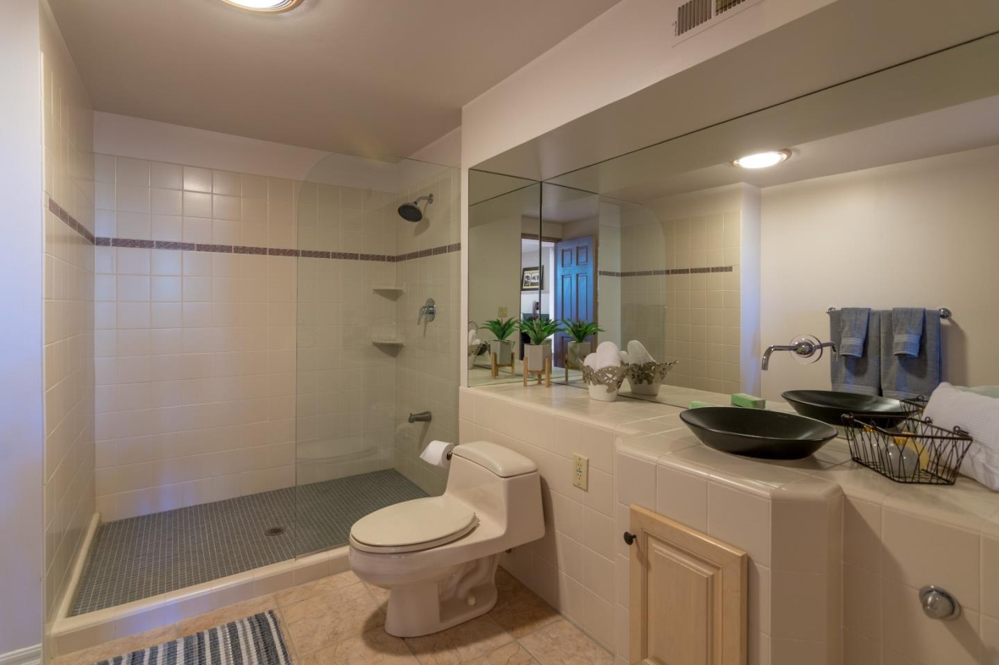 14795 Bohlman Road Saratoga, CA 95070 - Photo 23 of 50 a bathroom with a granite countertop sink a toilet and shower
