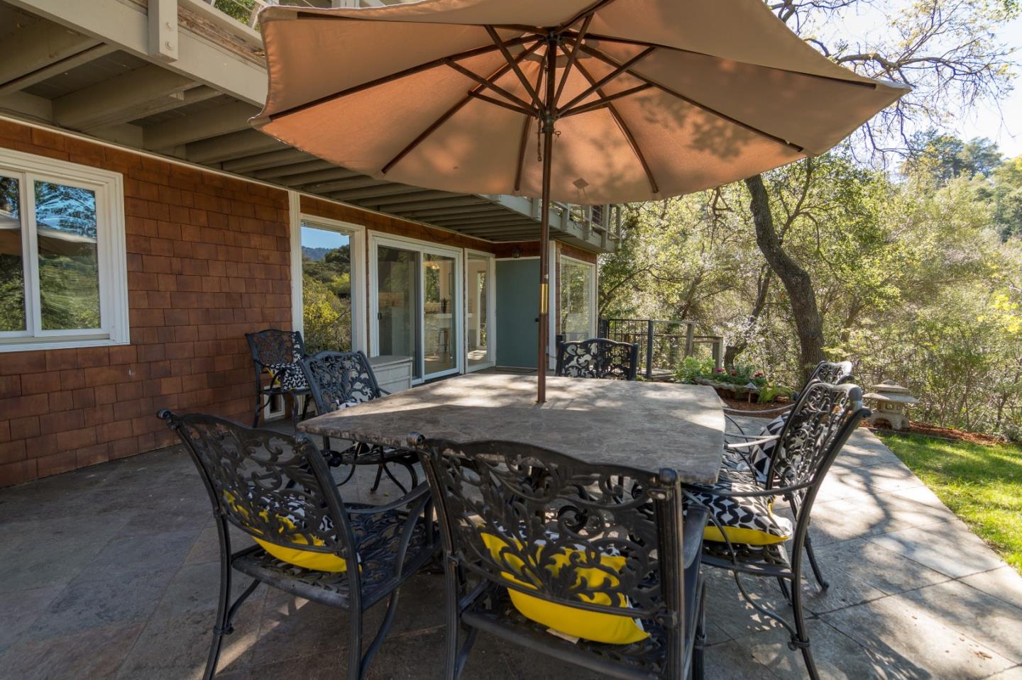14795 Bohlman Road Saratoga, CA 95070 - Photo 45 of 50 a view of a patio with table and chairs under an umbrella