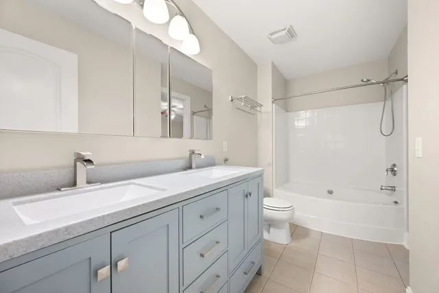 a bathroom with a double vanity sink toilet and shower