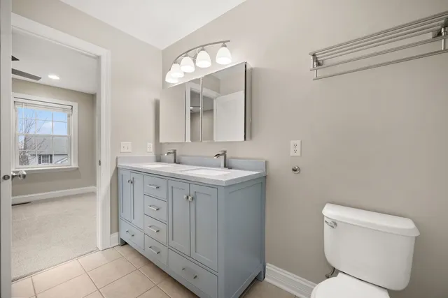 a spacious bathroom with a toilet sink and mirror