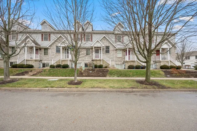 a view of a house with a yard and large tree