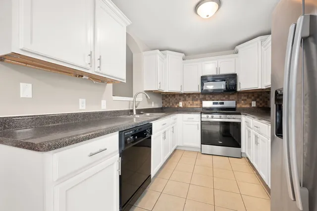 a kitchen with kitchen island granite countertop a stove top oven microwave and cabinets