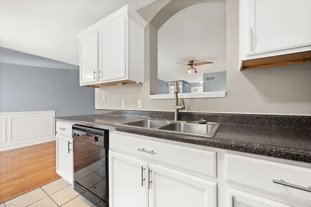 a kitchen with granite countertop white cabinets and a sink
