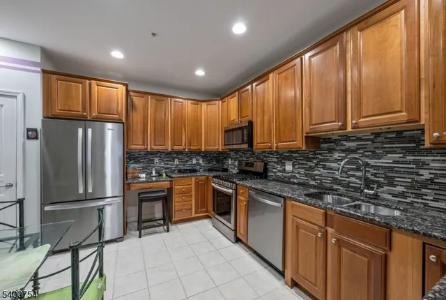 a kitchen with stainless steel appliances granite countertop a refrigerator and a sink