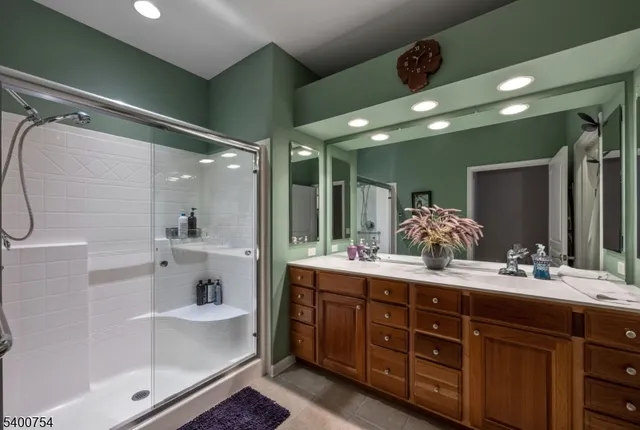 a bathroom with a double vanity sink a large mirror and shower