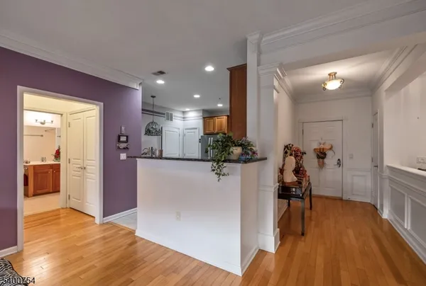 a view of a hallway with wooden floor windows and a living room