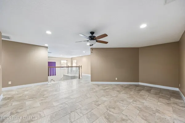 a view of an empty room with a ceiling fan