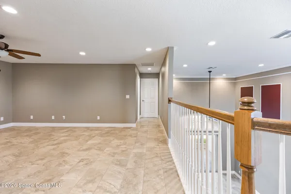 a view of a hallway with wooden floor and windows