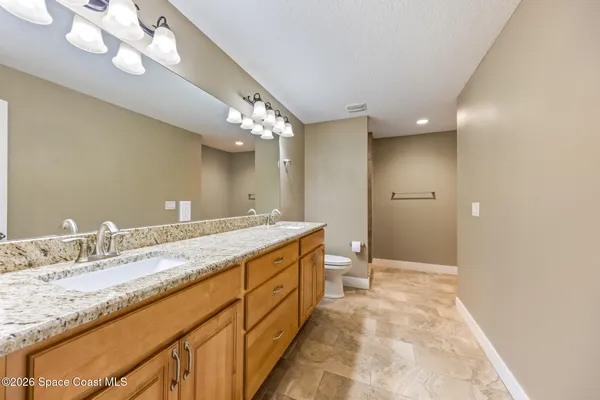 a bathroom with a granite countertop sink a large mirror and a shower