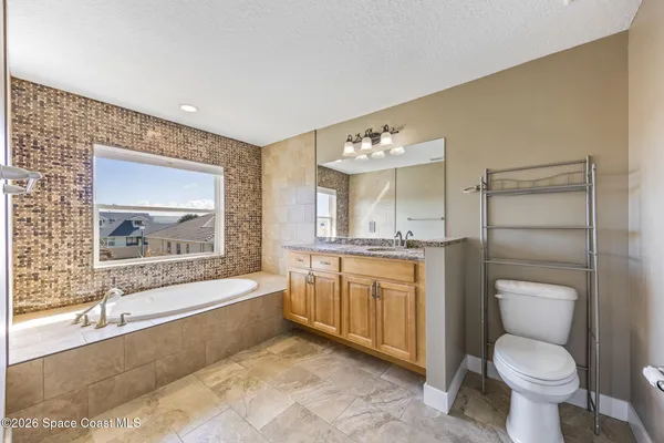 a bathroom with a granite countertop toilet a sink and bathtub