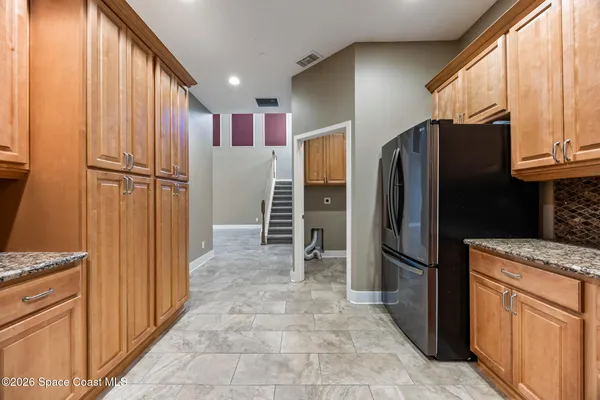 a kitchen with stainless steel appliances granite countertop a refrigerator and a sink