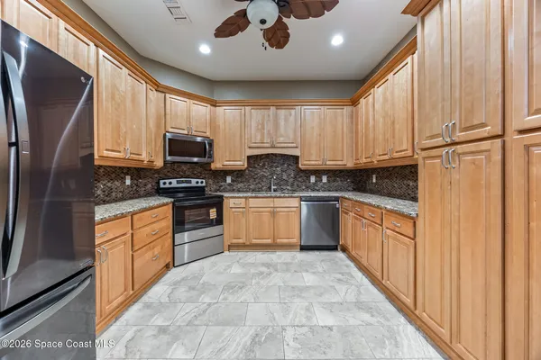 a kitchen with stainless steel appliances granite countertop a stove a sink and a refrigerator