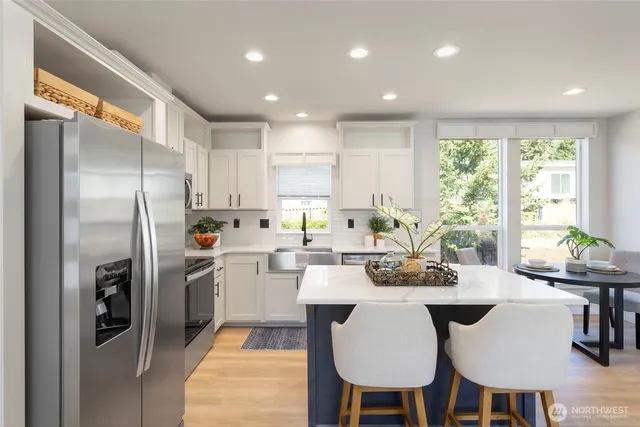 a kitchen with refrigerator and chairs
