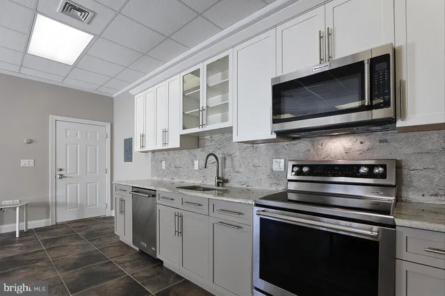 a kitchen with stainless steel appliances granite countertop a stove microwave and sink