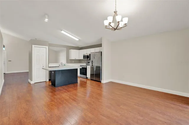 a view of kitchen with granite countertop cabinets and refrigerator