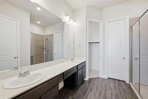 a spacious bathroom with a double vanity sink a mirror and a shower