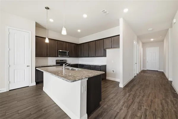a kitchen with kitchen island sink refrigerator and cabinets