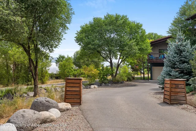 a backyard of a house with barbeque oven and trees