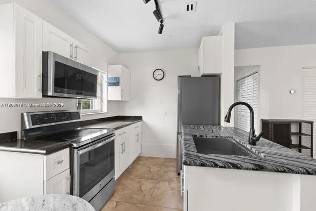 a kitchen with stainless steel appliances granite countertop a sink and a stove top oven with granite countertops
