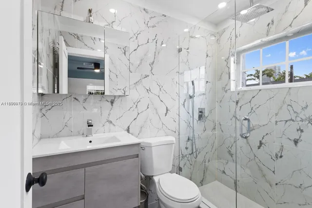a bathroom with a sink mirror vanity and toilet