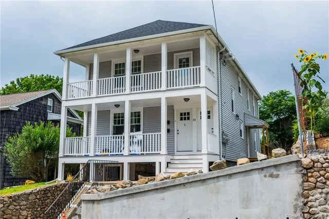 a front view of a house with a yard and balcony
