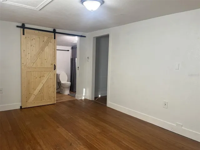 a view of an empty room with wooden floor
