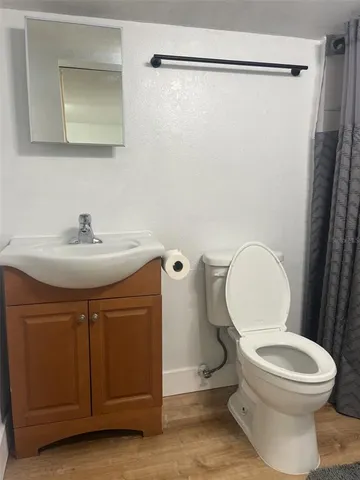 a bathroom with a sink a toilet a mirror and shower