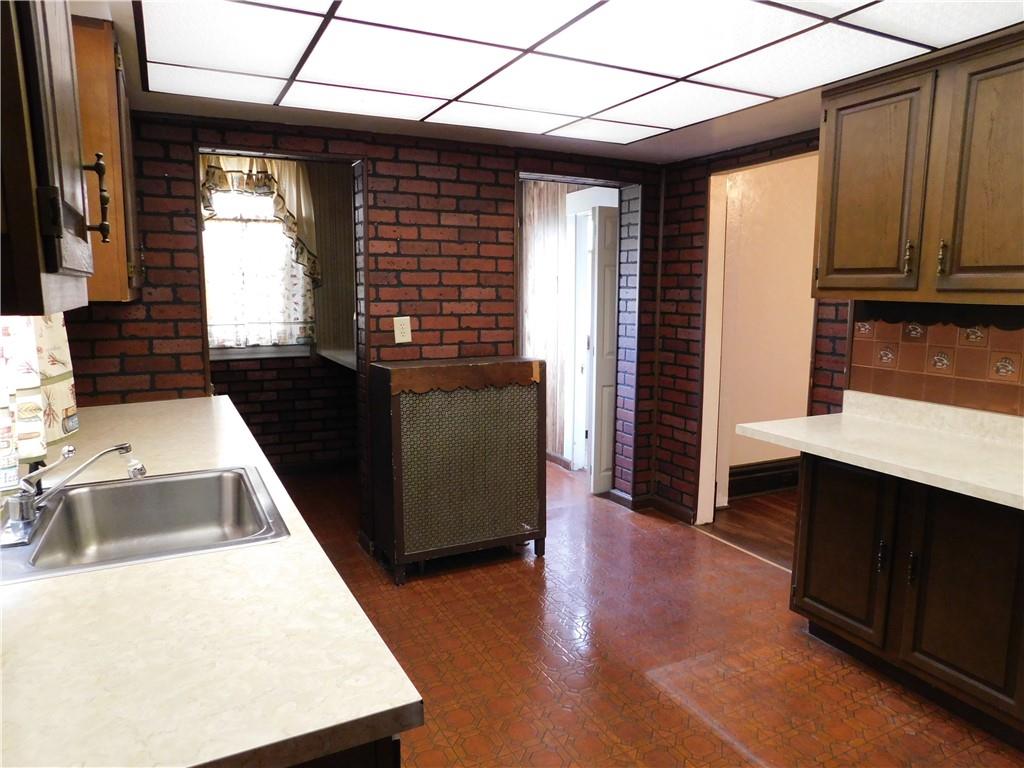 423 Alice Street Pittsburgh, PA 15210 - Photo 7 of 17 a view of a kitchen with a sink a microwave and furniture