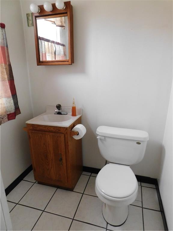 423 Alice Street Pittsburgh, PA 15210 - Photo 10 of 17 a bathroom with a toilet a sink and a mirror