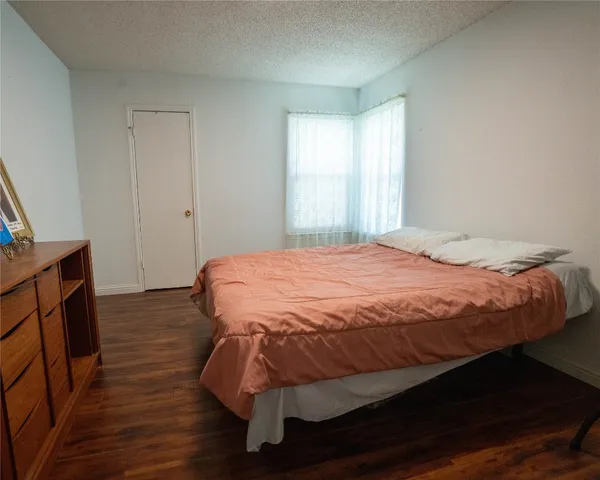 a large bed sitting in a bedroom next to a window